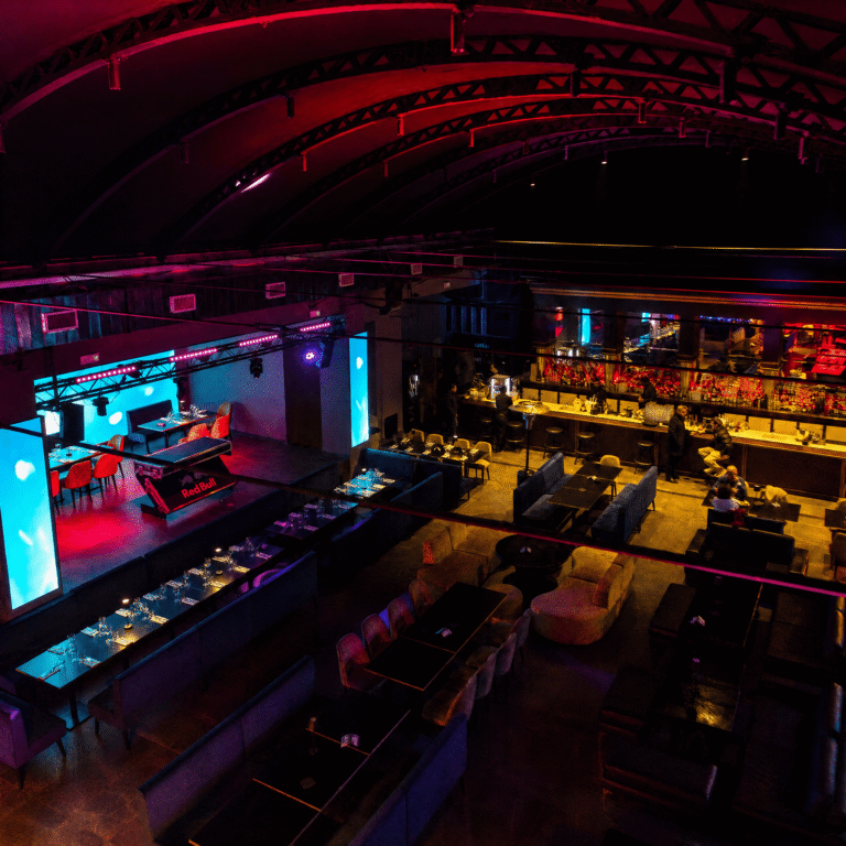 Sala interna del 55 Milano con tavoli, bancone bar e palco